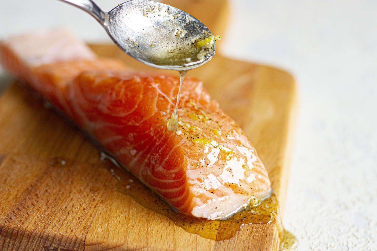 Salmon fillet on top of the wooden chopping board.