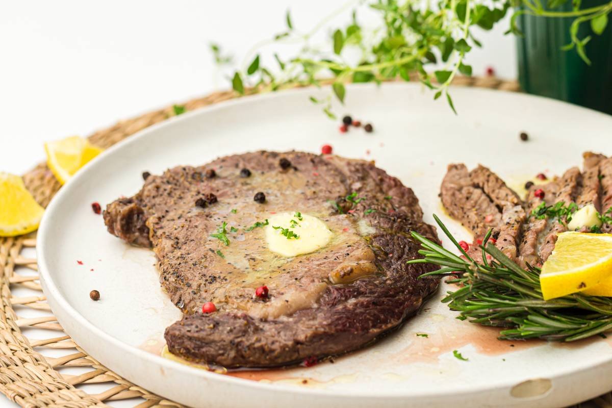 Air Fryer Steak in a white plate with herbs