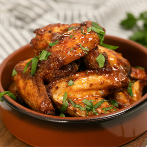 Sriracha Chicken Wings garnished with chopped parsley.