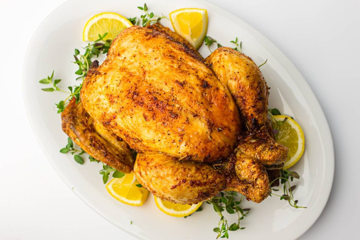 Whole Chicken on a white plate ready to be served.